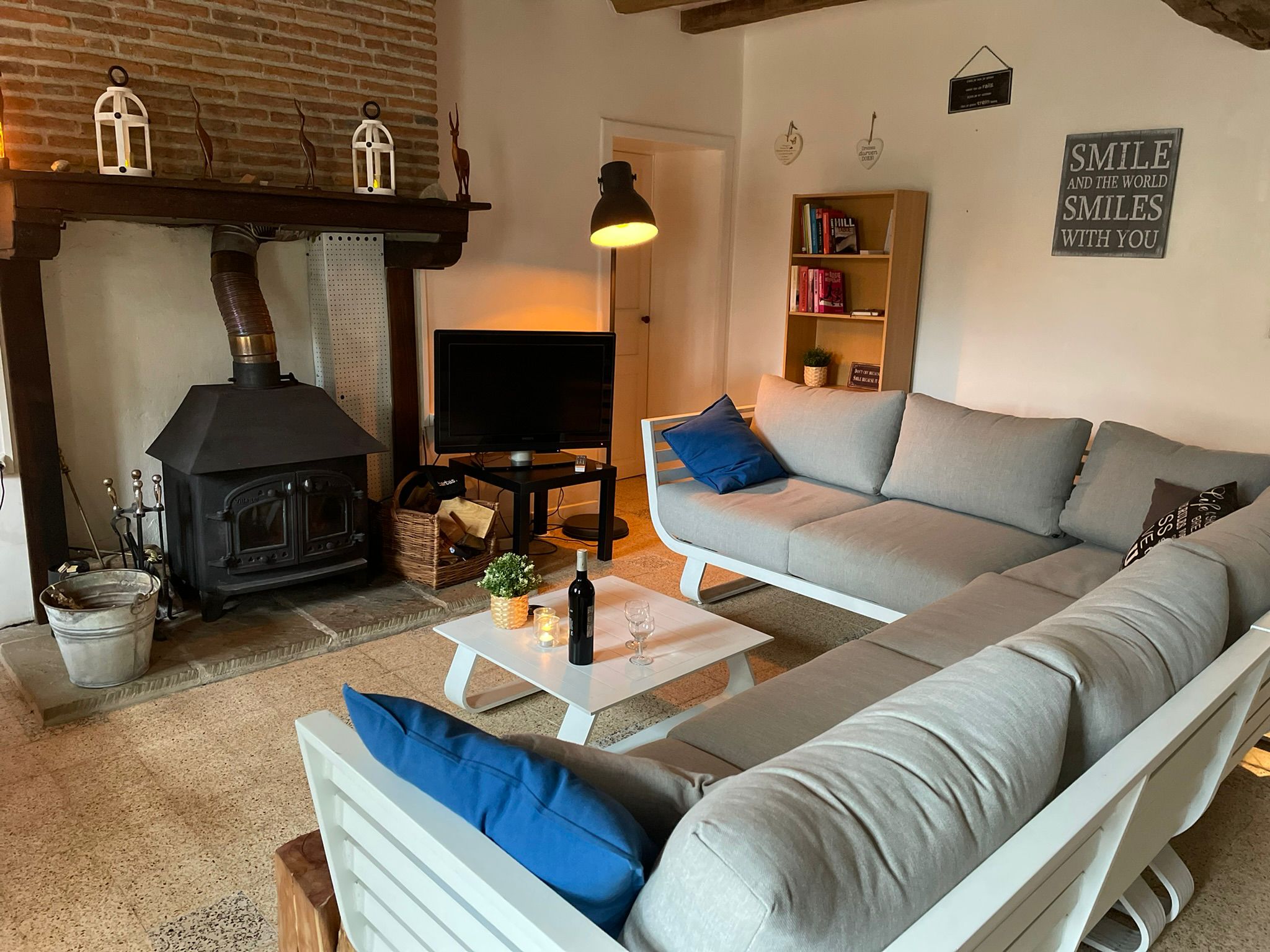 Gezellige woonkamer met houtkachel en sofa in de gîte