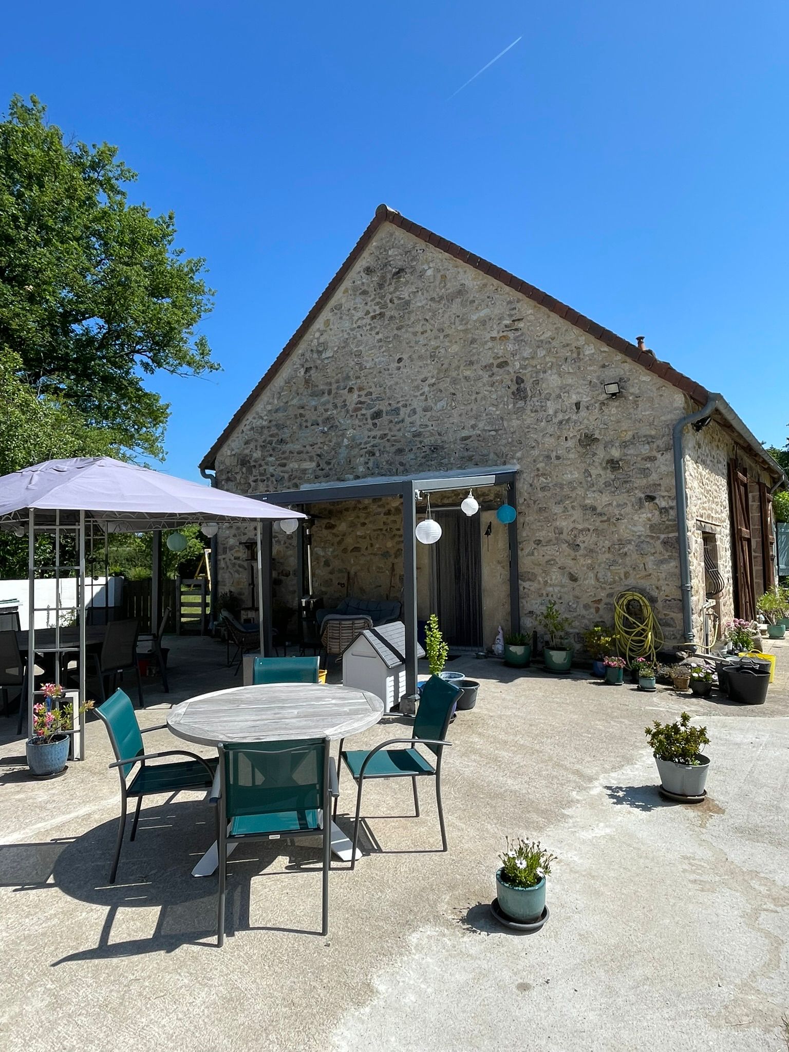 Zonnig terras met eettafel en pergola